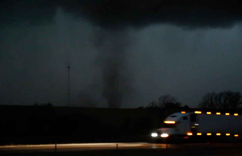 A tornado approaches Interstate 80 near Atlantic, Iowa, as a semi rolls eastward on Wednesday, Dec. 15, 2021. A band of strong storms swept across much of the plains states on Wednesday, producing powerful wind gusts and tornadoes.