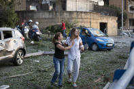 Injured stand after of a massive explosion in Beirut, Lebanon, Tuesday, Aug. 4, 2020. Massive explosions rocked downtown Beirut on Tuesday, flattening much of the port, damaging buildings and blowing out windows and doors as a giant mushroom cloud rose above the capital. Witnesses saw many people injured by flying glass and debris. (AP Photo/Hassan Ammar)