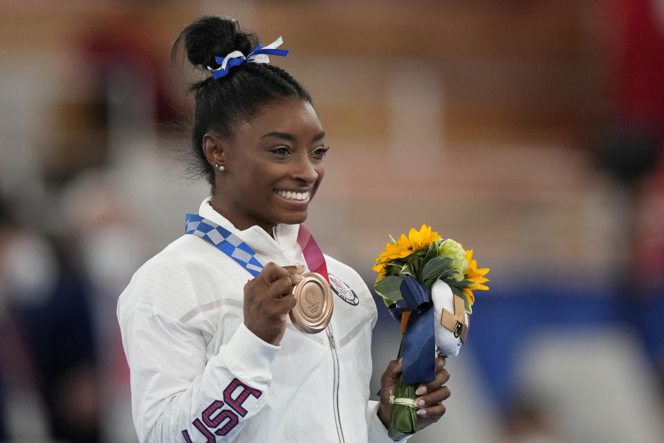 U.S. gymnast Simone Biles poses with her bronze medal for the artistic gymnastics women's balance beam apparatus at the 2020 Summer Olympics, Tuesday, Aug. 3, 2021, in Tokyo, Japan. (AP Photo/Natacha Pisarenko)