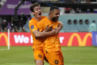 Memphis Depay of the Netherlands, right, celebrates with a teammate after scoring the opening goal of his team during the World Cup round of 16 soccer match between the Netherlands and the United States, at the Khalifa International Stadium in Doha, Qatar, Saturday, Dec. 3, 2022. (AP Photo/Martin Meissner)