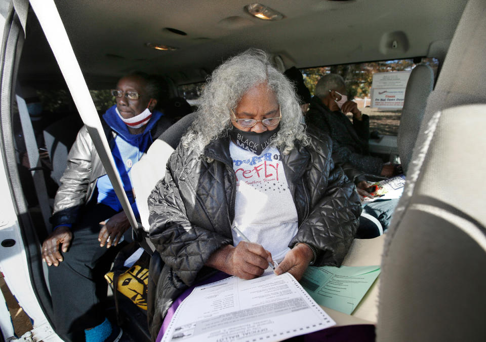 Jean Ward, 76, fills out her ballot on Tuesday, Nov. 3, 2020 in Richmond, Va.  A felony record from when she was in her 30s meant she lost the right to vote years ago. After working hard to have her voting rights restored, Ward boarded a van along with other seniors residents of Highland Park Senior Apartments to cast her ballot at the Engine 15 precinct.  (James H Wallace/Richmond Times-Dispatch via AP)