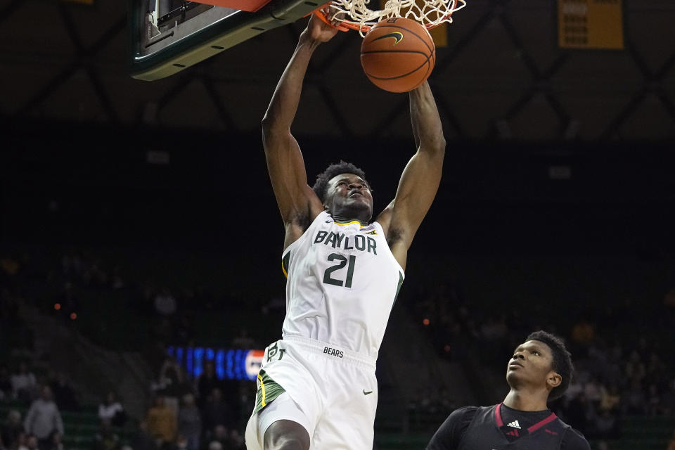 Baylor center Yves Missi (21) slam dunks against Nicholls State forward Mekhi Collins during the first half of an NCAA college basketball game in Waco, Texas, Tuesday, Nov. 28, 2023. (AP Photo/LM Otero)