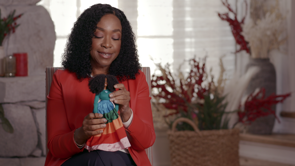 Shonda Rhimes, an executive producer of the documentary "Black Barbie," admires a version of the doll modeled in her image.