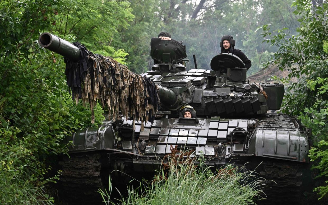 Ukrainian servicemen check their T-72 tank at a position in the Donetsk region