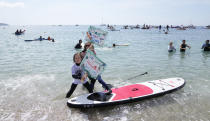 Paddleboarders and surfers take part in a paddle out to raise awareness for climate action in the sea at Gyllyngvase Beach in Falmouth, Cornwall, England, Saturday, June 12, 2021. Leaders of the G7 gather for a second day of meetings on Saturday, in which they will discuss COVID-19, climate, foreign policy and the economy. (AP Photo/Alastair Grant)