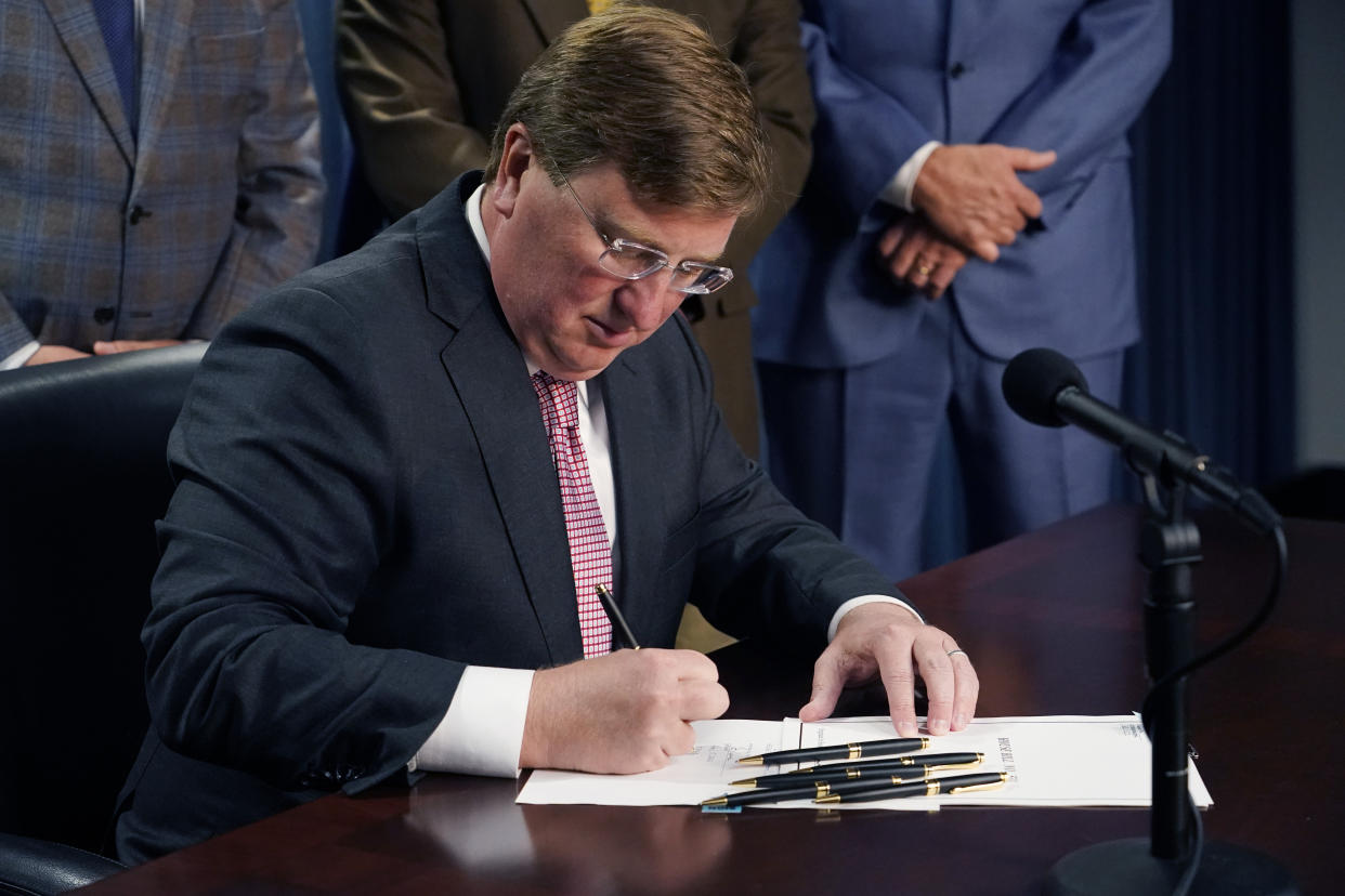 Republican Gov. Tate Reeves signs a bill that will reduce the state income tax over four years, beginning in 2023, at his office in Jackson, Miss., Tuesday, April 5, 2022. (AP Photo/Rogelio V. Solis)