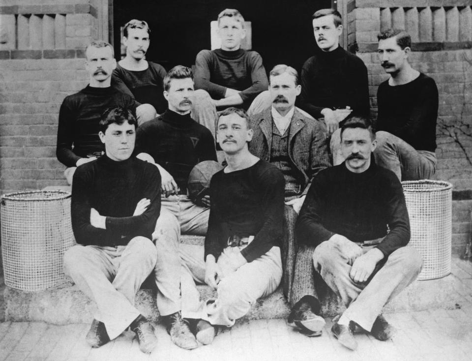 James Naismith (in the middle, wearing a jacket) and the first basketball team. (Bettmann Archives/Getty Images)