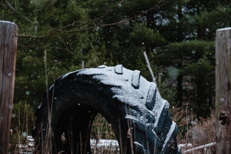 Snow falls last week on an abandoned tractor tire in Lawrence Township.