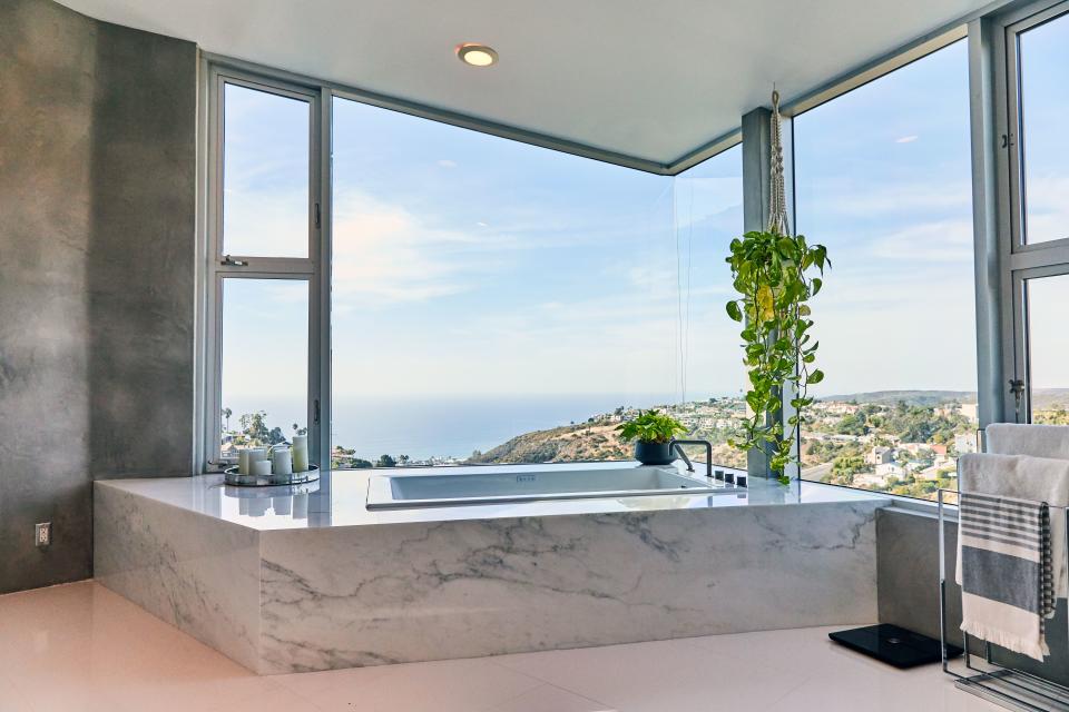 A friend connected Huston with a marble company in Los Angeles, where he chose the pieces fitted around his massive tub, which he does soak in from time to time. “I love the way it turned out, the modern look of it,” he says. "And the plants there, too, help out with the good vibe.”