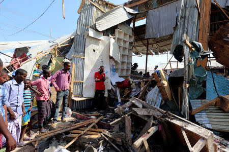 Traders look at a stall destroyed at the scene of a suicide bomb explosion at the Wadajir market in Madina district of Somalia's capital Mogadishu February 19, 2017. REUTERS/Feisal Omar