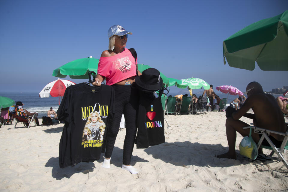 Rosimeri Vieira vende camisetas y gorras de Madonna previo a su concierto en la paya de Copacabana en Río de Janeiro, Brasil, el lunes 29 de abril de 2024. (Foto AP/Bruna Prado)
