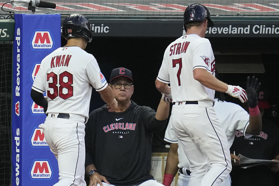 Cleveland Guardians' Steven Kwan (38) and Myles Straw (7) are greeted by Terry Francona, center, after scoring on single by Amed Rosario in the seventh inning of a baseball game against the Atlanta Braves, Monday, July 3, 2023, in Cleveland. (AP Photo/Sue Ogrocki)
