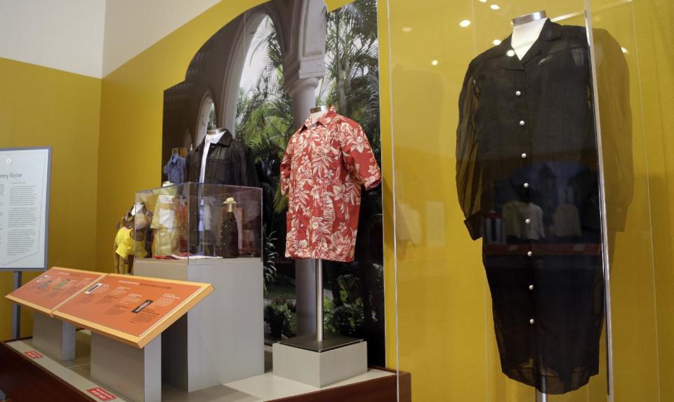 In this Wednesday, Oct. 17, 2012 photo, a guayabera worn by salsa queen Celia Cruz, right, is on display alongside more contemporary pieces, at an exhibition titled "The Guayabera: A Shirt's Story" at the Museum of History Miami, in Miami. This is the first exhibition to trace the story of the shirt's evolution through Cuba, Mexico, and the United States. (AP Photo/Lynne Sladky)