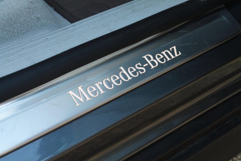 The words "Mercedes-Benz" illuminated on the door sill of the Mercedes-Benz EQE SUV. 