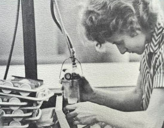 A female employee meticulously adds a piece to a Bissell carpet sweeper.