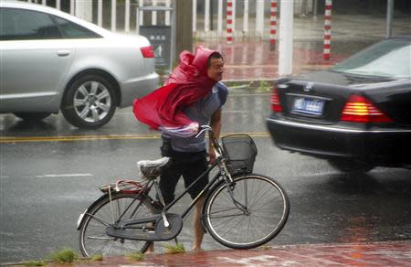 A man pushes his bicycle against the wind as Typhoon Usagi approaches Shantou, Guangdong province