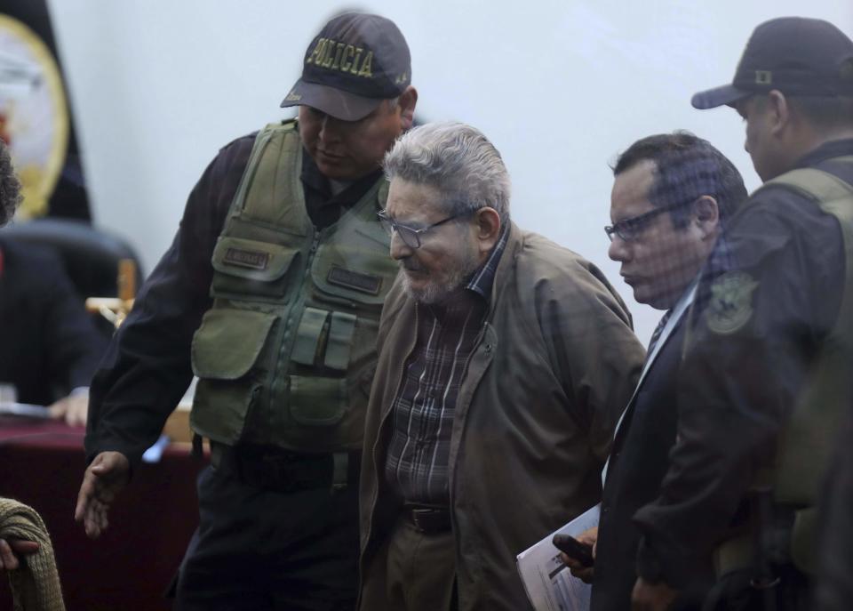 In this photo taken through a window, Abimael Guzman, founder and leader of the Shining Path guerrilla movement, arrives to court at a military base in Callao, Peru, Tuesday, Sept. 11, 2018. On Tuesday, the historic leader of the terrorist group Shining Path will be sentenced for his role in a 1992 car bomb that killed 25 people in Lima. (AP Photo/Martin Mejia)