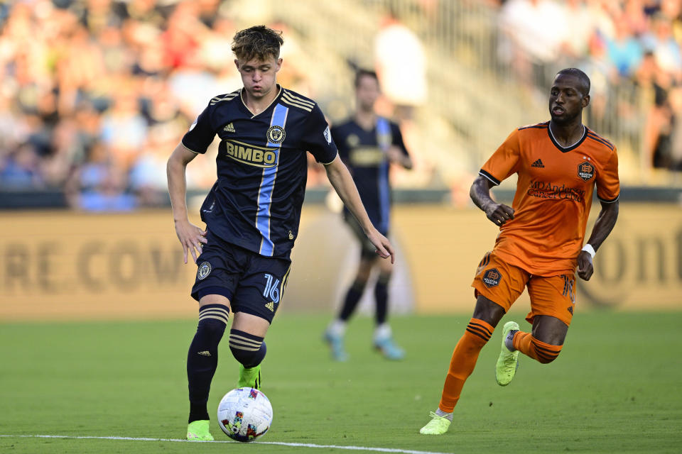 Philadelphia Union's Jack McGlynn, left, runs the ball past Houston Dynamo's Fafà Picault during the first half of an MLS soccer match, Saturday, July 30, 2022, in Chester, Pa. (AP Photo/Derik Hamilton)