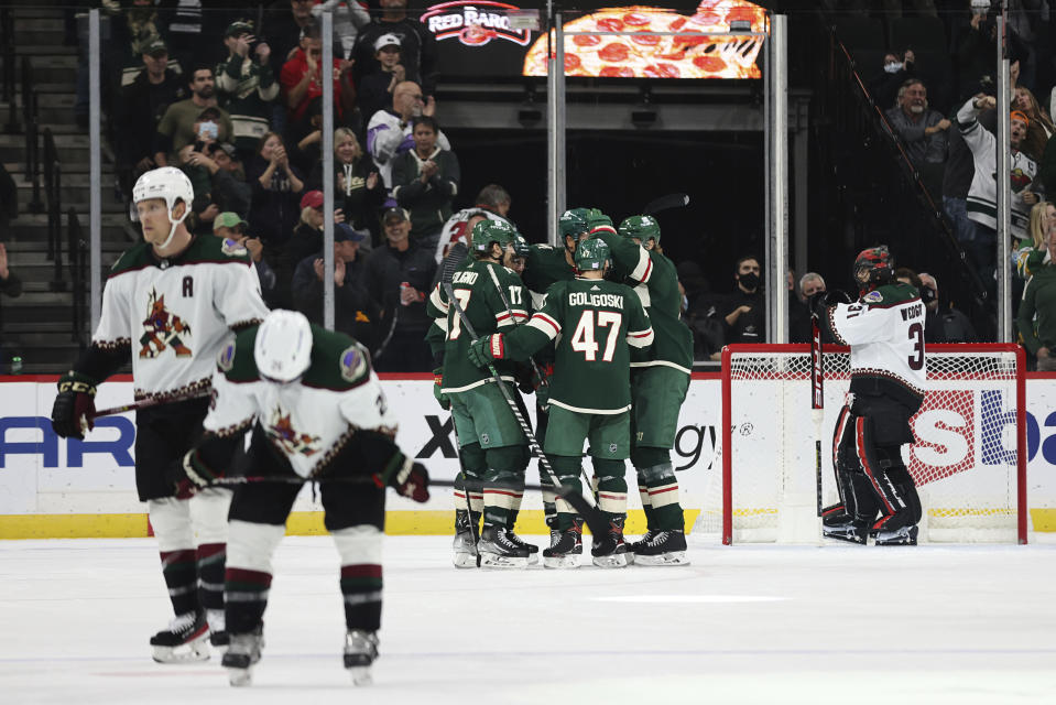 Minnesota Wild players celebrate around left wing Jordan Greenway after he scored a goal against the Arizona Coyotes during the second period of an NHL hockey game Tuesday, Nov. 30, 2021, in St. Paul, Minn. (AP Photo/Stacy Bengs)