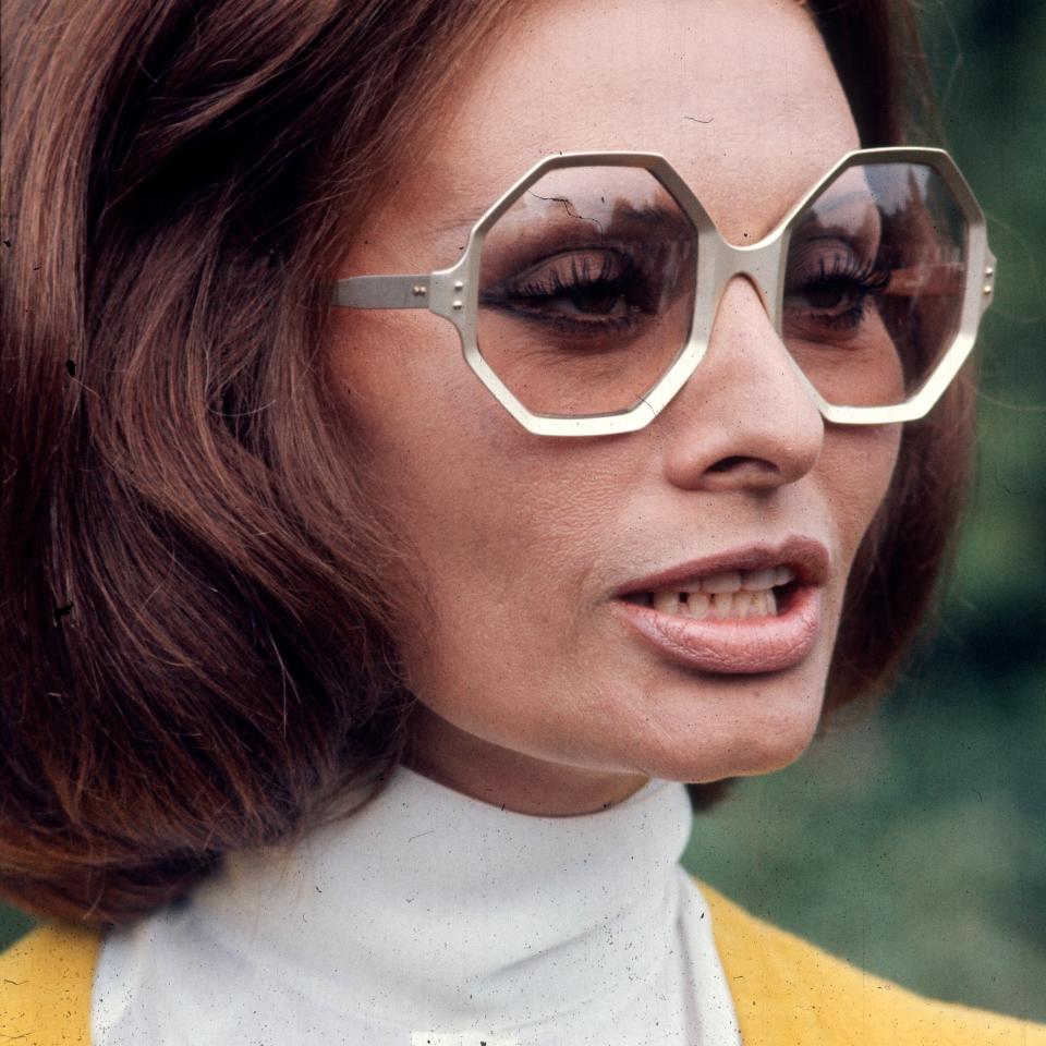 Sophia Loren in a white high-neck top and large, stylish geometric sunglasses