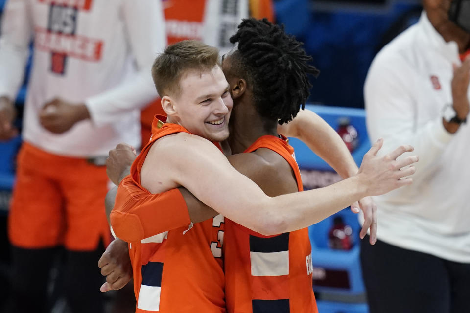 Syracuse's Buddy Boeheim and Quincy Guerrier hug following a second-round game against West Virginia in the NCAA men's college basketball tournament at Bankers Life Fieldhouse, Sunday, March 21, 2021, in Indianapolis. Syracuse defeated Syracuse 75-72. (AP Photo/Darron Cummings)