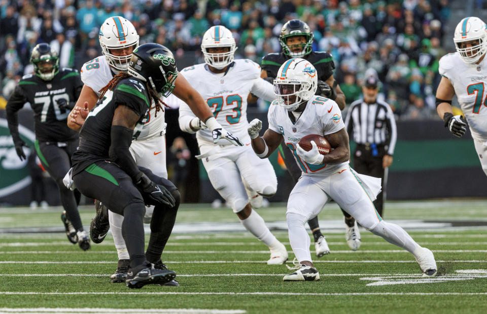 Miami Dolphins wide receiver Tyreek Hill (10) runs with the football during first quarter of an NFL football game against the New York Jets, Friday, Nov. 24, 2023, in East Rutherford, N.J. (David Santiago/Miami Herald via AP)