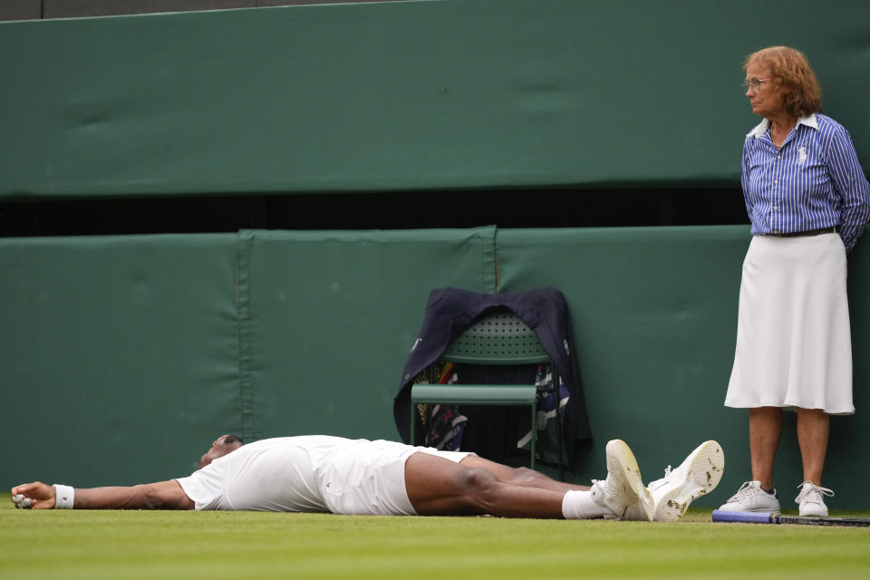 FILE - A line judge looks as Gael Monfils of France lies on the court after during his third round match against Grigor Dimitrov of Bulgaria at the Wimbledon tennis championships in London, on July 5, 2024. That long-held Wimbledon tradition of line judges dressed in elegant uniforms is no more. The All England Club has announced that artificial intelligence will be used to make the 'out' and 'fault' calls at the championships from 2025. (AP Photo/Kirsty Wigglesworth, File)