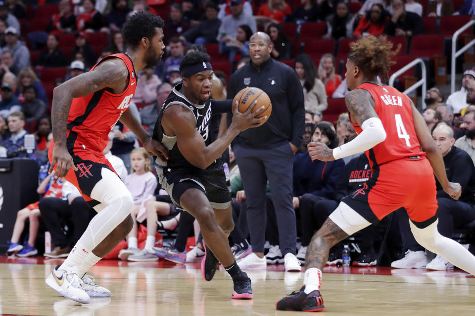 Sacramento Kings guard Terence Davis III, center, drives between Houston Rockets forward Tari Eason, left, and guard Jalen Green (4) during the first half of an NBA basketball game Wednesday, Feb. 8, 2023, in Houston. (AP Photo/Michael Wyke)