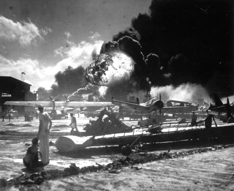 <p>In this image provided by the U.S. Navy, sailors stand among wrecked airplanes at Ford Island Naval Air Station as they watch the explosion of the USS Shaw in the background, during the Japanese surprise attack on Pearl Harbor, Hawaii, on December 7, 1941. (AP Photo/U.S. Navy) </p>