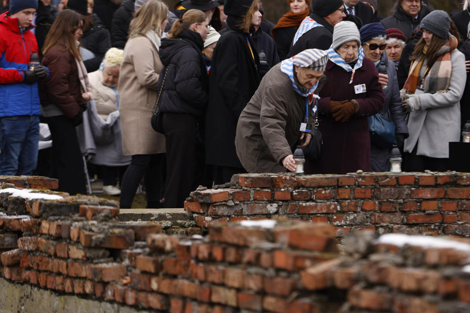 Holocaust survivors place candles at the former crematorium as they attend a ceremony in the former Nazi German concentration and extermination camp Auschwitz during ceremonies marking the 78th anniversary of the liberation of the camp in Brzezinka, Poland, Friday, Jan. 27, 2023. (AP Photo/Michal Dyjuk)