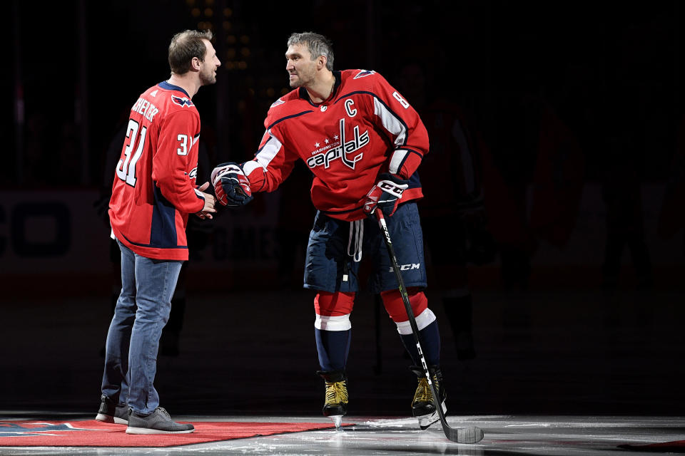 Washington Nationals baseball player Max Scherzer, left, meets with Washington Capitals left wing Alex Ovechkin (8), of Russia, after a ceremonial puck drop before an NHL hockey game between the Capitals and the New York Rangers, Friday, Oct. 18, 2019, in Washington. Scherzer substituted a baseball for a puck. (AP Photo/Nick Wass)