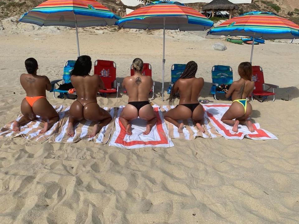 Megan Thee Stallion and friends pose topless on a beach