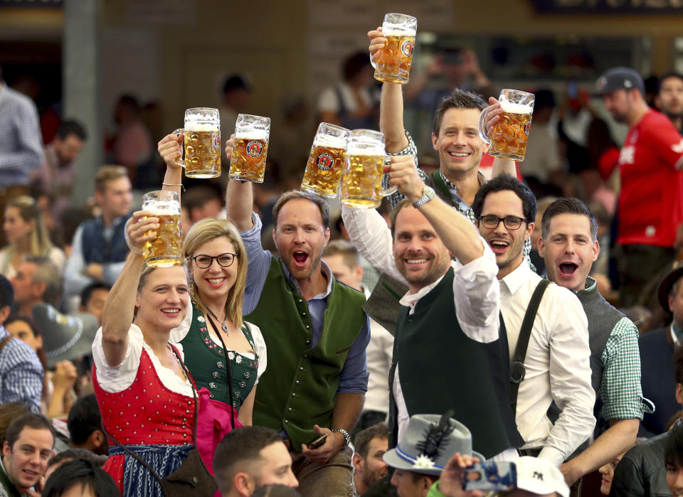 FILE - Visitors lift glasses of beer during the opening of the 186th 'Oktoberfest' beer festival in Munich, Germany, on Sept. 21, 2019. The Oktoberfest is on tap again in Germany after a two-year pandemic interruption. The beer will be just as cold and the pork knuckle just as juicy. But brewers and visitors are under pressure from inflation in ways they could hardly imagine in 2019. (AP Photo/Matthias Schrader, File)