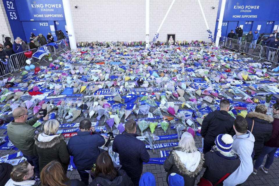 Supporters pay tribute outside Leicester City Football Club after a helicopter crashed in flames the day before, in Leicester, England, Sunday, Oct. 28, 2018. A helicopter belonging to Leicester City's owner, Thai billionaire Vichai Srivaddhanaprabha, crashed in flames in a car park next to the soccer club's stadium shortly after it took off from the field following a Premier League game on Saturday night. (Aaron Chown/PA via AP)