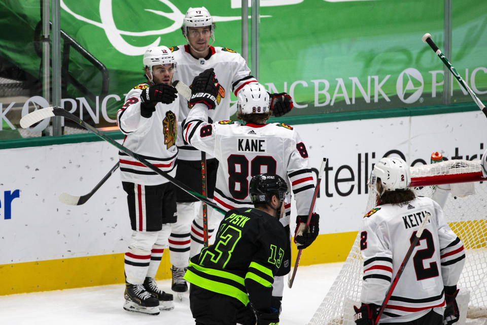 Chicago Blackhawks left wing Alex DeBrincat (12) celebrates with teammate Patrick Kane (88) after scoring a goal during the second period of an NHL hockey game against the Dallas Stars, Sunday, Feb. 7, 2021, in Dallas. (AP Photo/Sam Hodde)