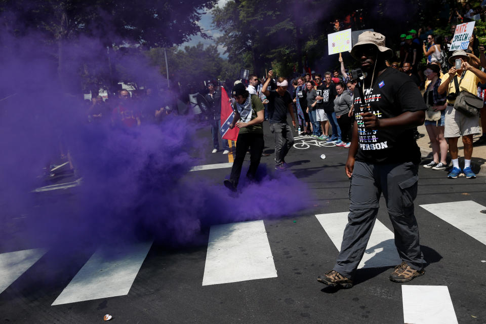 A smoke bomb is thrown at a group of counter-protesters.