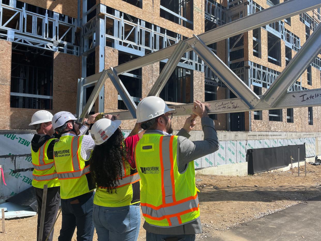 Members of the construction team at Vista at Brighton sign the final steel beam before it's installed, Wednesday, May 1.