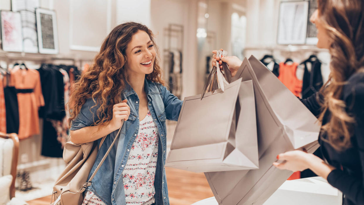 Young woman taking her shopping bags in a fashion store.