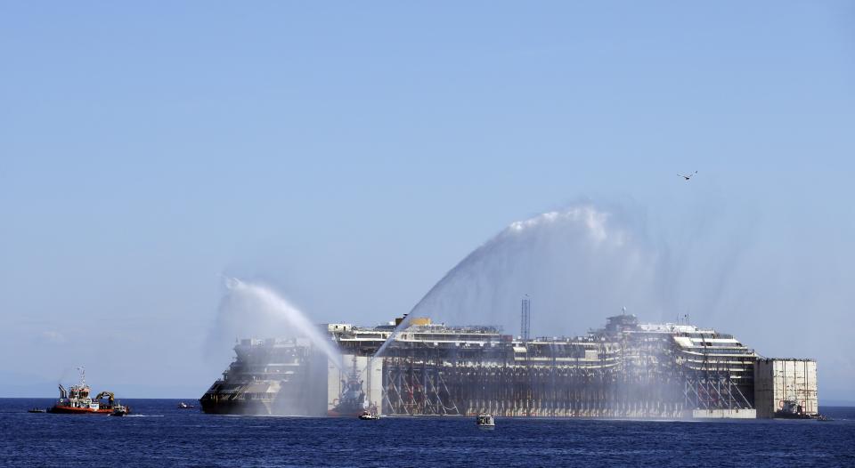 Tugboats spays water in farewell to the cruise liner Costa Concordia during the refloat operation maneuvers at Giglio Island July 23, 2014. (REUTERS/ Max Rossi)