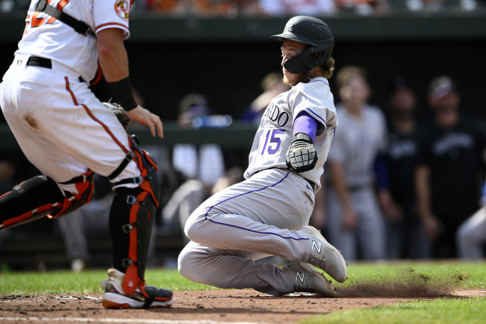 Colorado Rockies' Hunter Goodman, right, slides towards home past Baltimore Orioles catcher James McCann to score on a ground out by Elias Diaz during the ninth inning of a baseball game, Sunday, Aug. 27, 2023, in Baltimore. The Rockies won 4-3. (AP Photo/Nick Wass)
