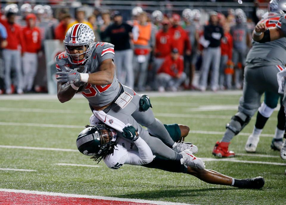 Ohio State Buckeyes running back TreVeyon Henderson (32) scores a touchdown as Michigan State Spartans linebacker Jordan Hall (5) makes the tackle during the second quarter at Ohio Stadium in Columbus, Ohio, on Saturday, Nov. 11, 2023.