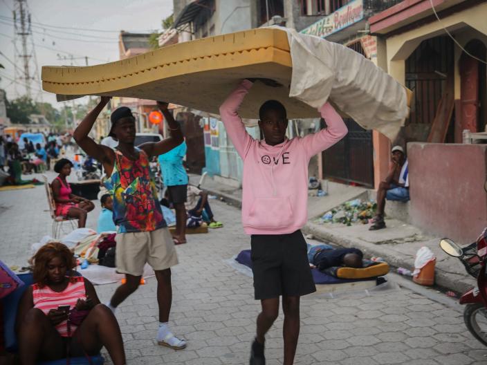 Men carry a mattress as people sleep on the streets after Saturday&#x002019;s 7.2 magnitude earthquake in Les Cayes, Haiti, Sunday, Aug. 15, 2021 (AP)