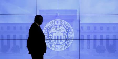 A security guard walks in front of an image of the Federal Reserve following the two-day Federal Open Market Committee (FOMC) policy meeting in Washington, March 16, 2016. REUTERS/Kevin Lamarque