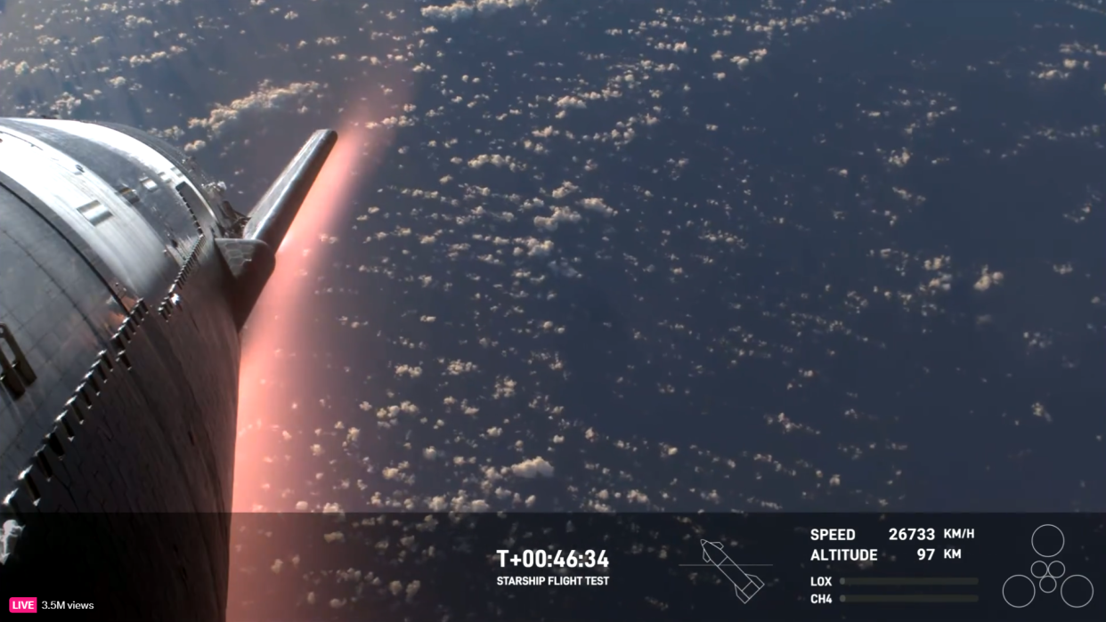  A silver spacecraft glows red with the heat of reentry, with earth's ocean in the background. 