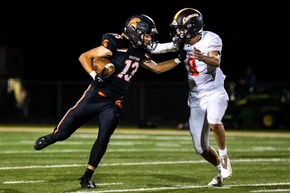 Solon's Sean Stahle (13) stiff-arms Washington's Ethan Patterson on Friday.