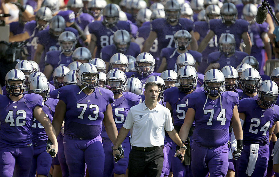 FILE - In this Sept. 27, 2014, file photo, St. Thomas coach Glenn Caruso leads his team onto the field for an NCAA college football game against St. John's in St. Paul, Minn. (Jim Gehrz/Star Tribune via AP, File)