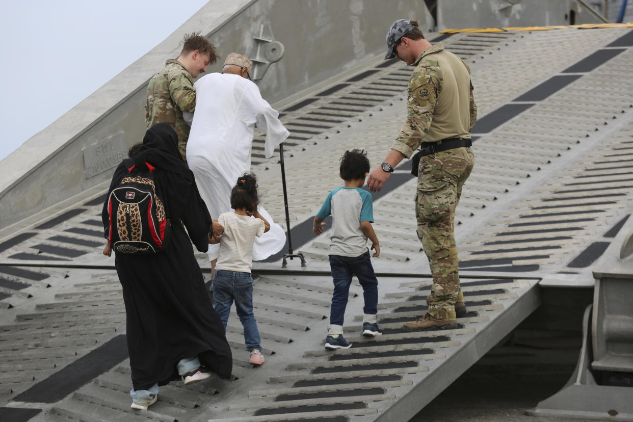 U.S. soldiers escort American nationals to a U.S. Navy ship in Port Sudan.