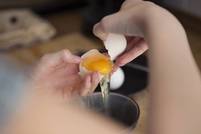 A person separating egg yolks from the whites