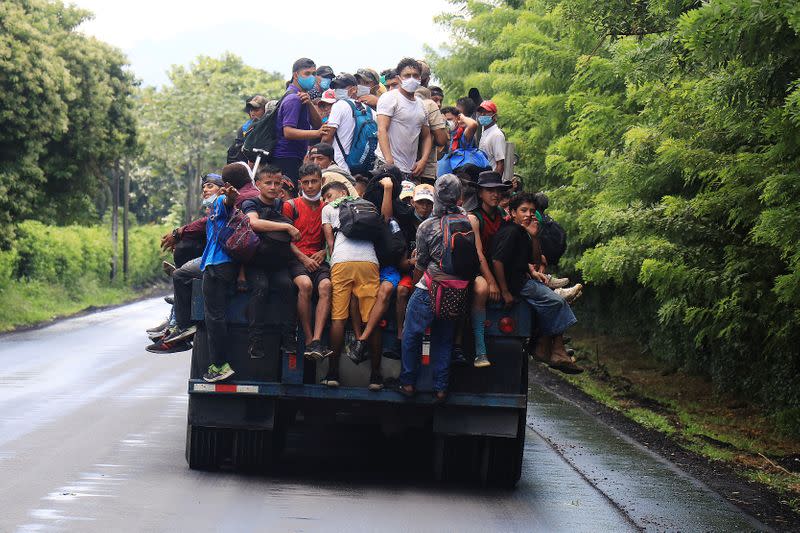 Honduran migrants trying to reach the U.S. hitchhike on a truck after bursting through a border checkpoint to enter Guatemala illegally, in Entre Rios
