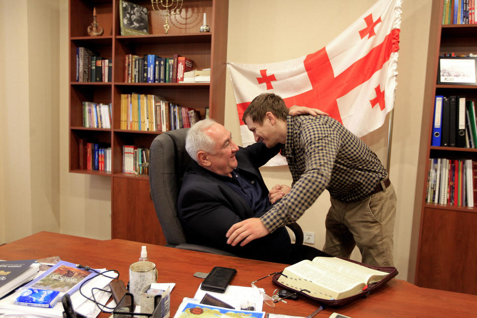 Dmitriy Zadoyanov, right, an evacuee from Mariupol, and Oleg Khubashvili, bishop of the Georgian Church of Evangelical Faith, greet each other in Tbilisi, Georgia, Sunday, April 17, 2022. Exhausted, freezing and hungry in a basement shelter in Mariupol, Zadoyanov finally accepted the idea of evacuation. The Russians told him he could board a bus to either Zaporizhzhia in Ukraine or Rostov-on-Don in Russia but in fact all the buses went to Russia. (AP Photo/Shakh Aivazov)